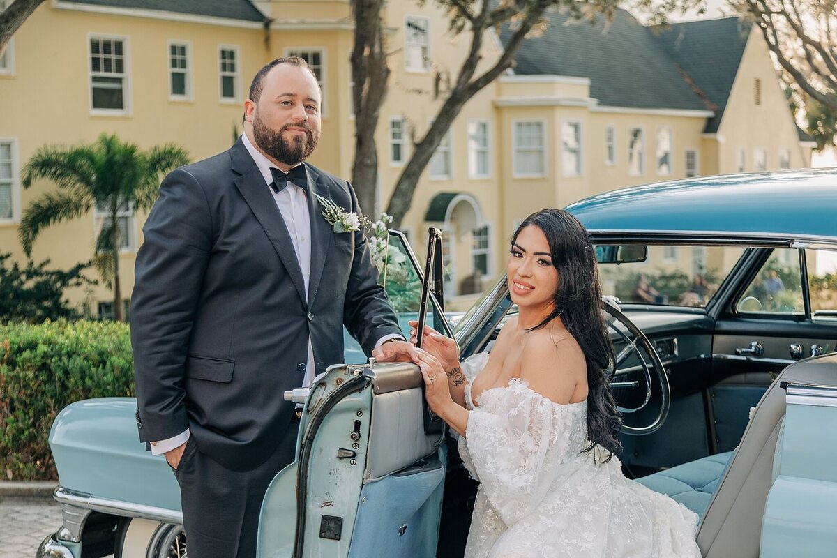 bride and groom pose at a vintage car at Lakeside Inn