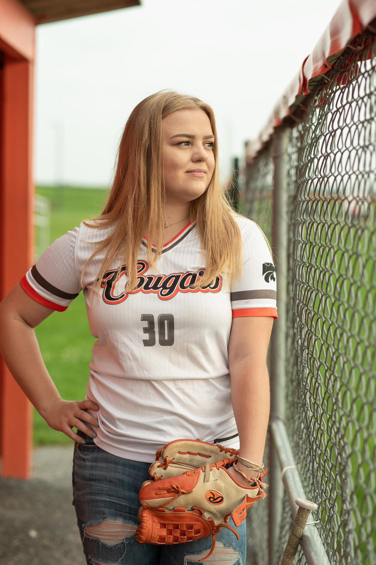 Senior girl in softball jersey and glove