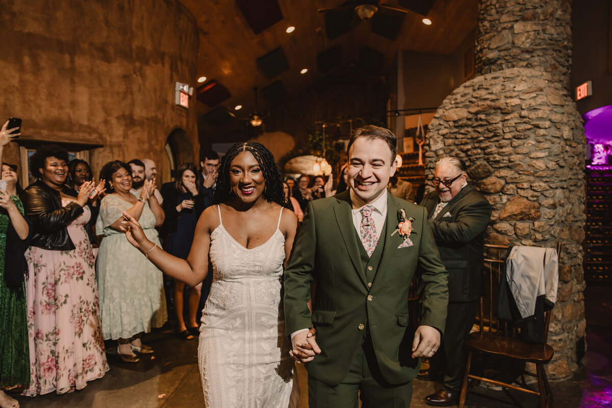 A newlywed couple holding hands as they walk together 