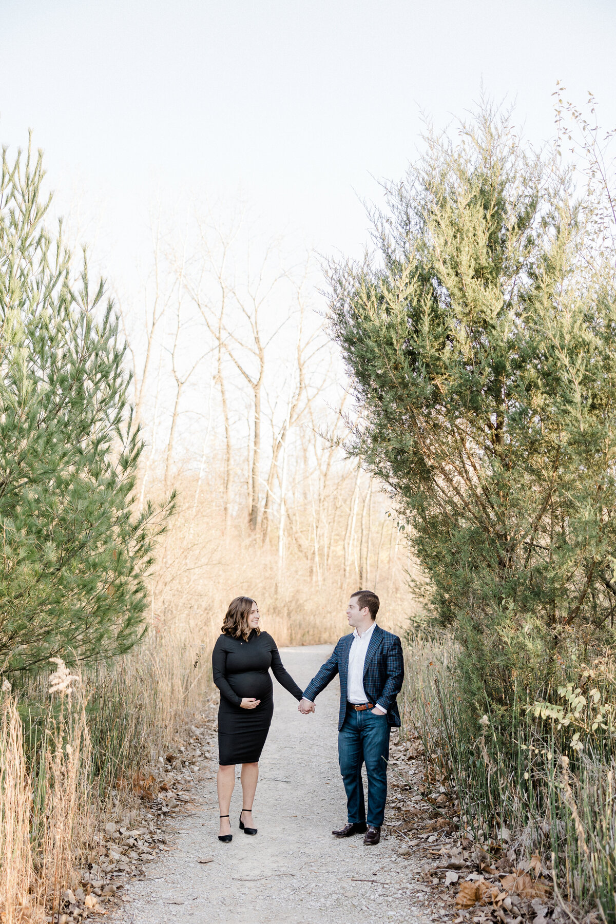 husband and wife holding hands along gravel pathway