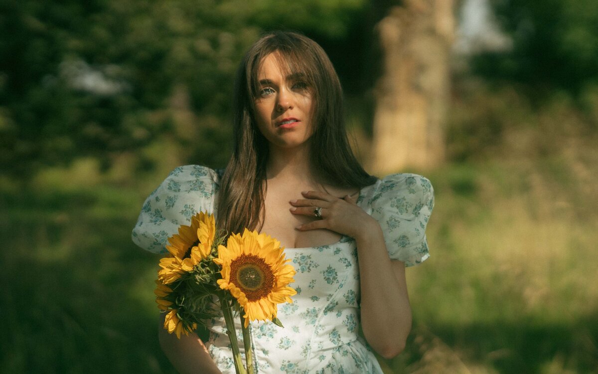 A radiant woman holding vibrant sunflowers, exuding warmth and joy, with natural light enhancing the beauty of this captivating moment