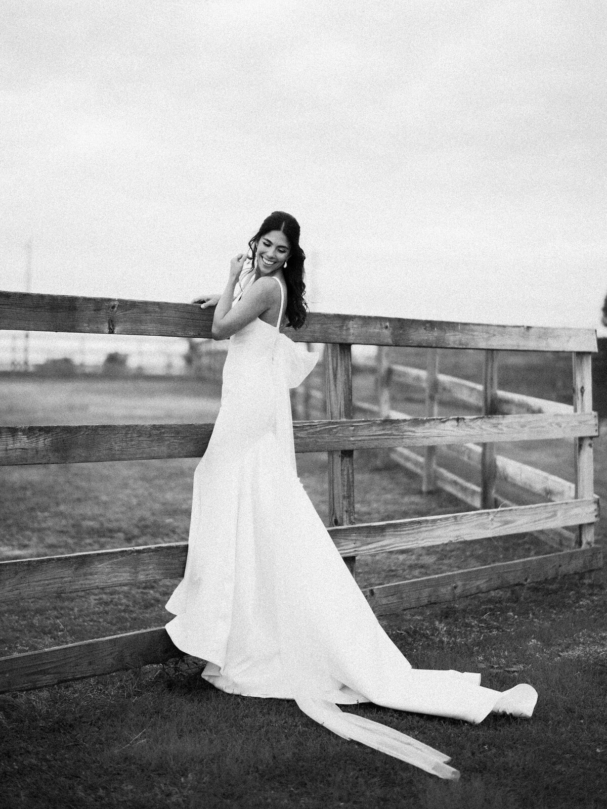 bride with bow running in field at the farmhouse in texas
