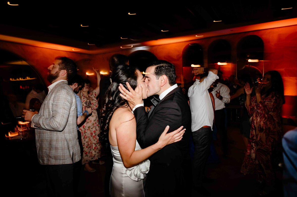 Bride and groom kiss on the dance floor