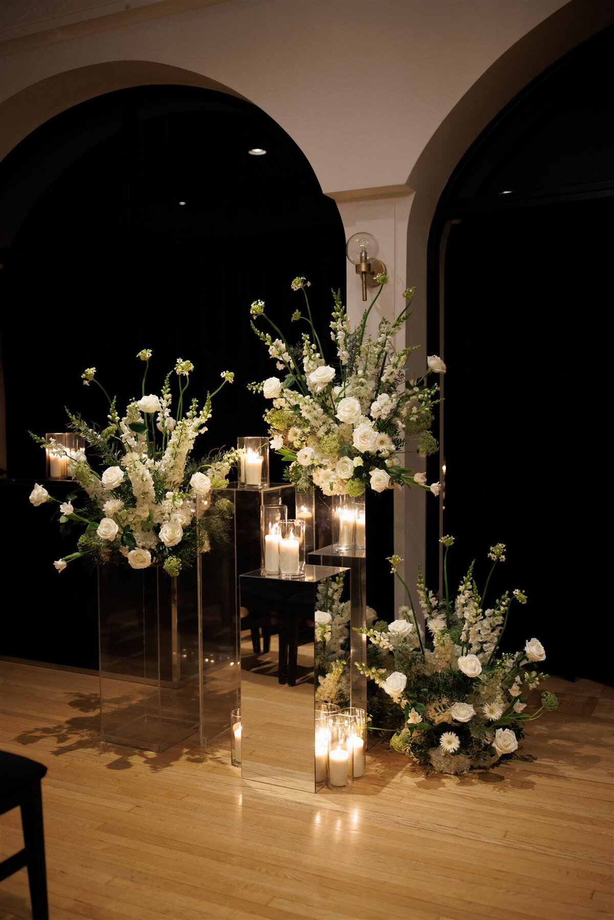 Romantic lighting and large white floral arrangements for a wedding ceremony at the Atwater Club.