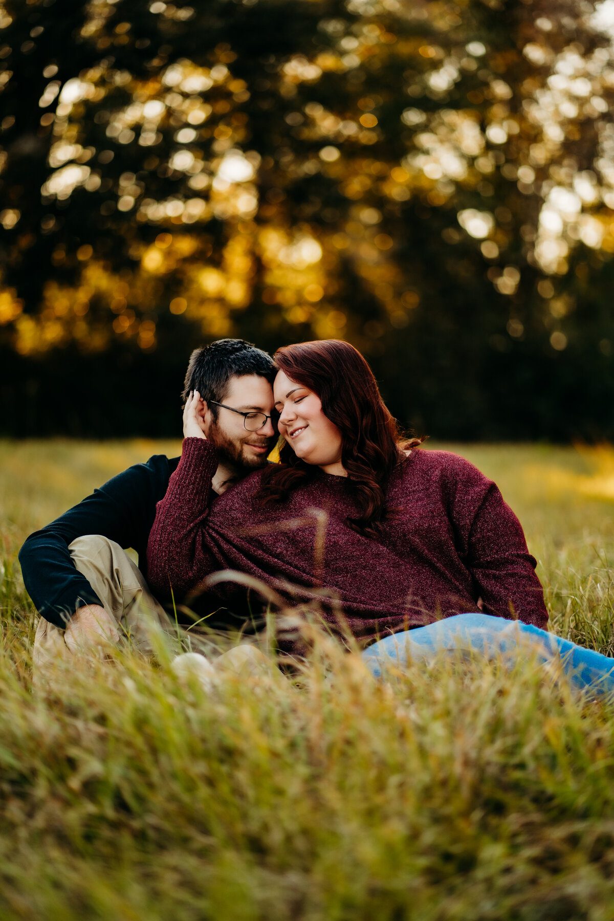 candid engagement photo of couple cuddling in field in Lafayette, la