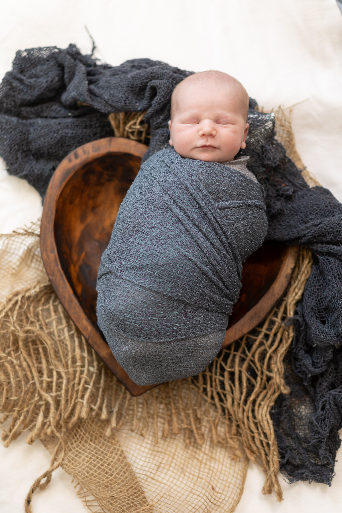 Newborn wrapped with a blue blanket