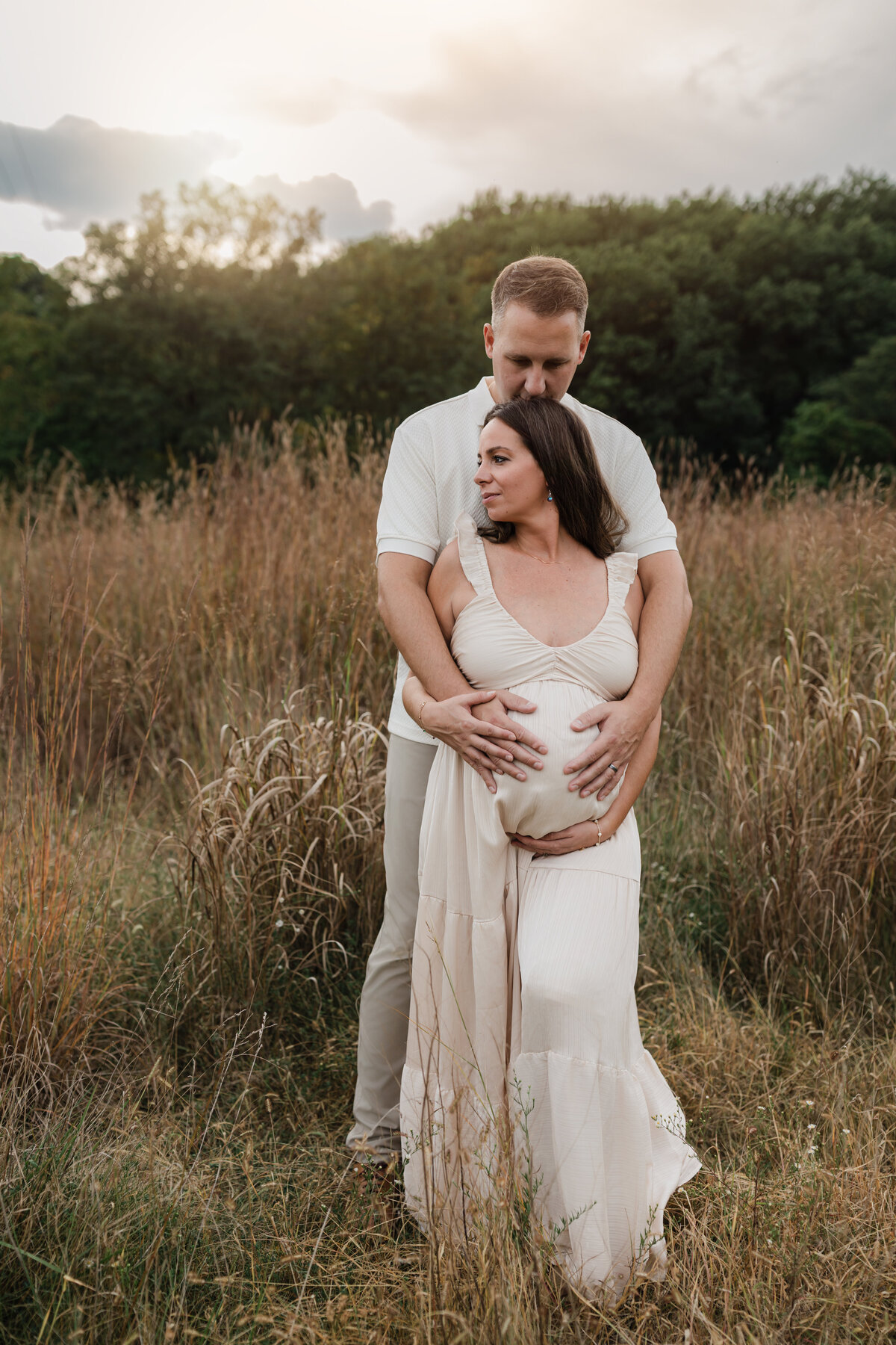 husband and pregnant wife in pink silk maternity gown holding baby bump for maternity photoshoot cleveland maternity photographer