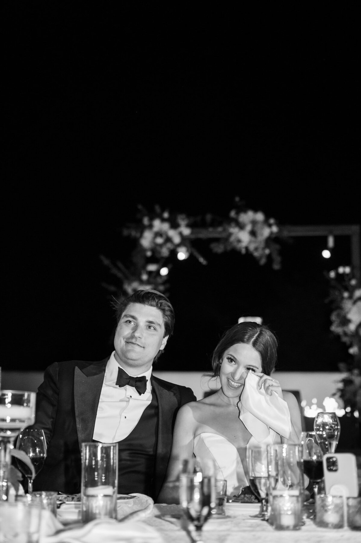 Bride and Groom listening to a toast while bride wipes a tear away