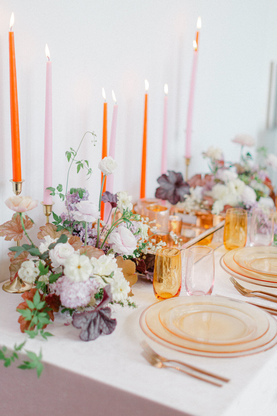 Floral lilac centrepieces line a table with bright candles at a Montreal wedding reception.