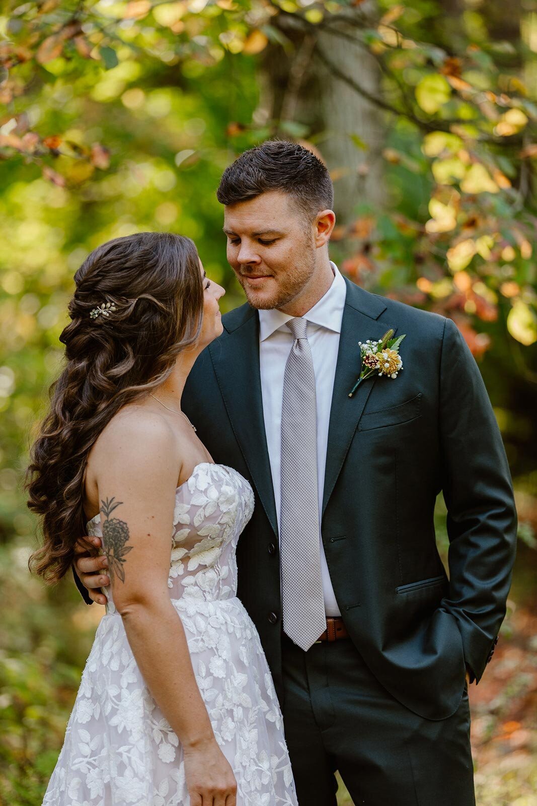 A bride and groom smiling atone another on their fall wedding day. 