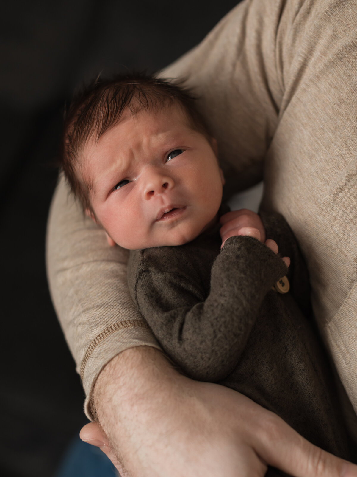 dad holding newborn son for in home lifestyle session cleveland newborn photographer