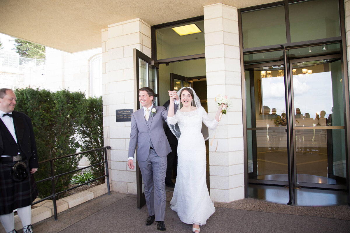 happy wedding couple exiting lds temple after wedding ceremony