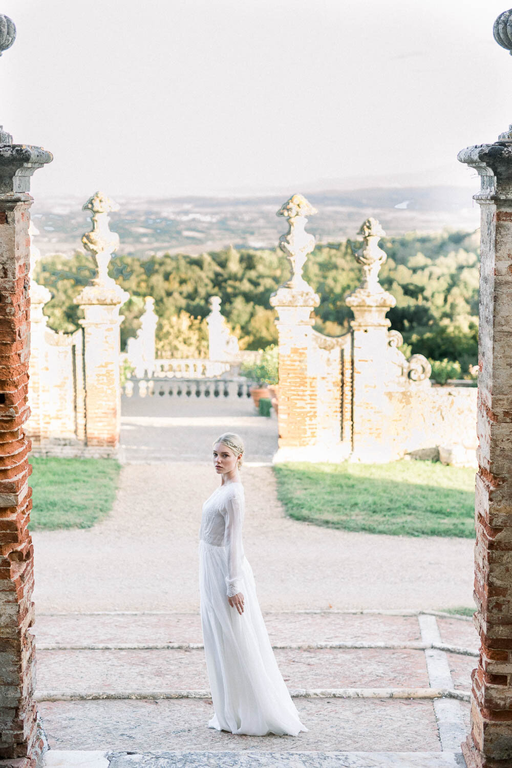 bride posing in front of gardens in castello di celsa