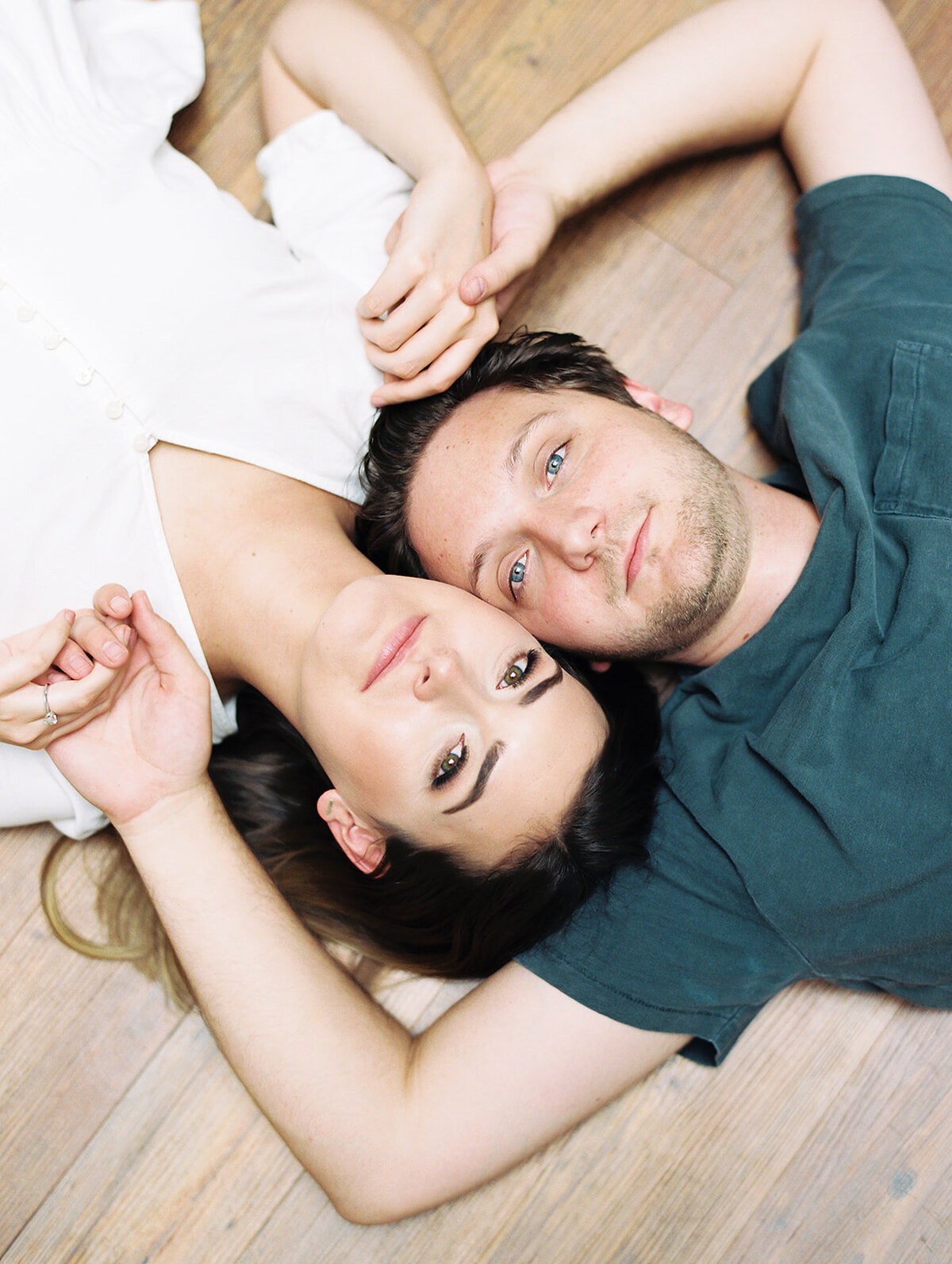Couple laying on the floor with their heads together