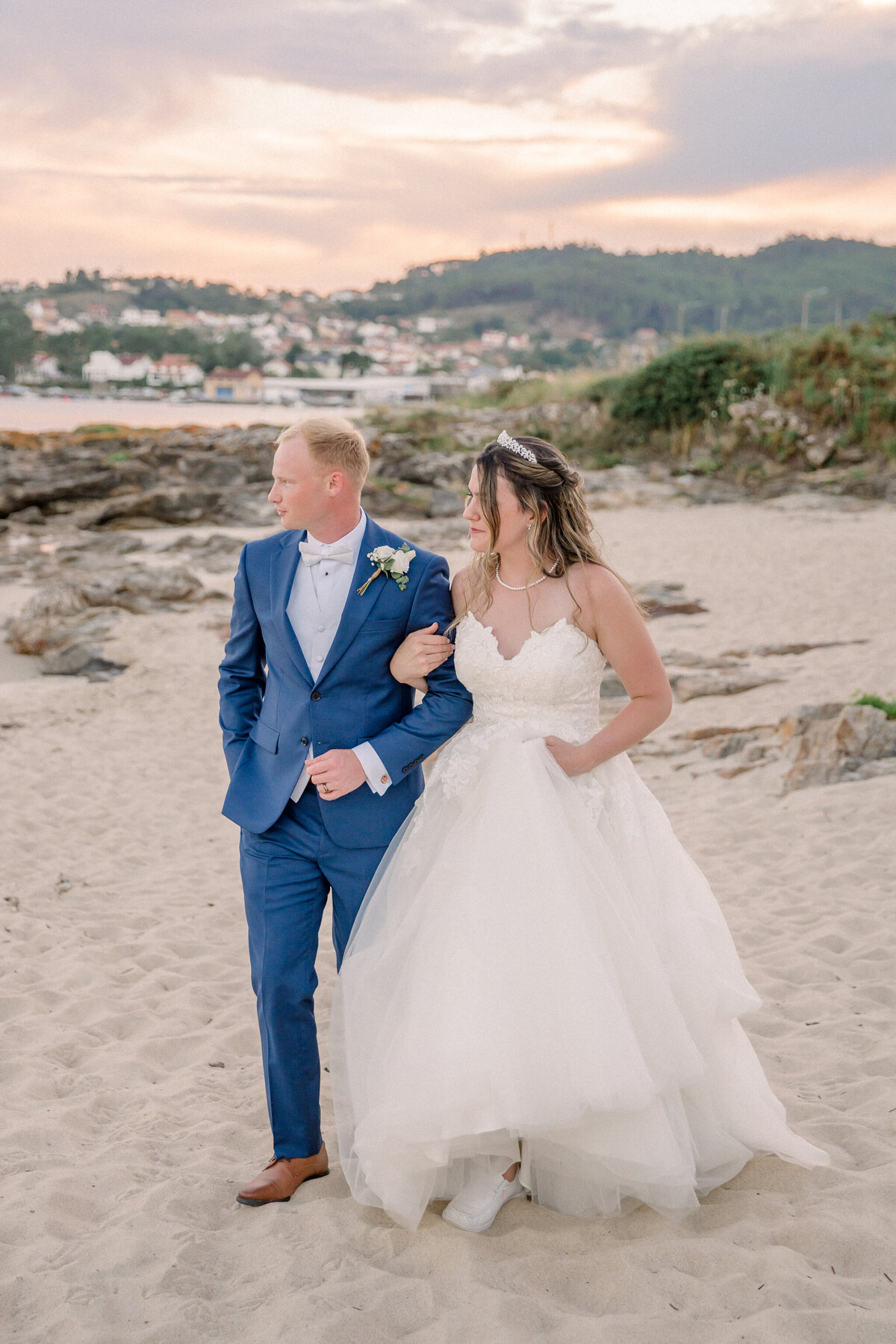 Wedding in Spain | bride and groom walk arm in arm on the beach