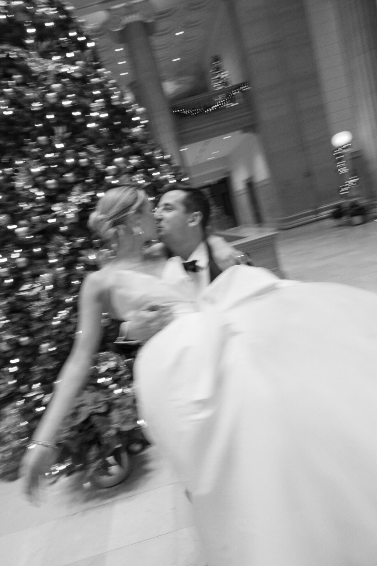 A blurred photo of the bridge and groom kissing next to the christmas tree in the Palmer House Chicago.