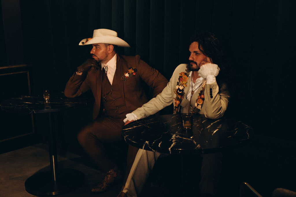 A wedding couple sitting in chairs next to each other.