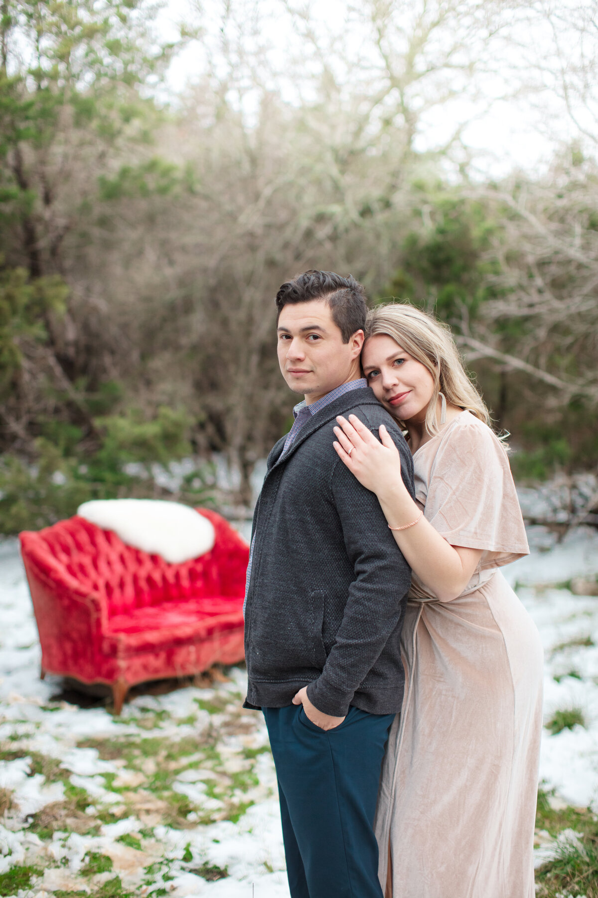 engagement session red velvet couch  in snow wooded  by New Braunfels wedding photographer Firefly Photography