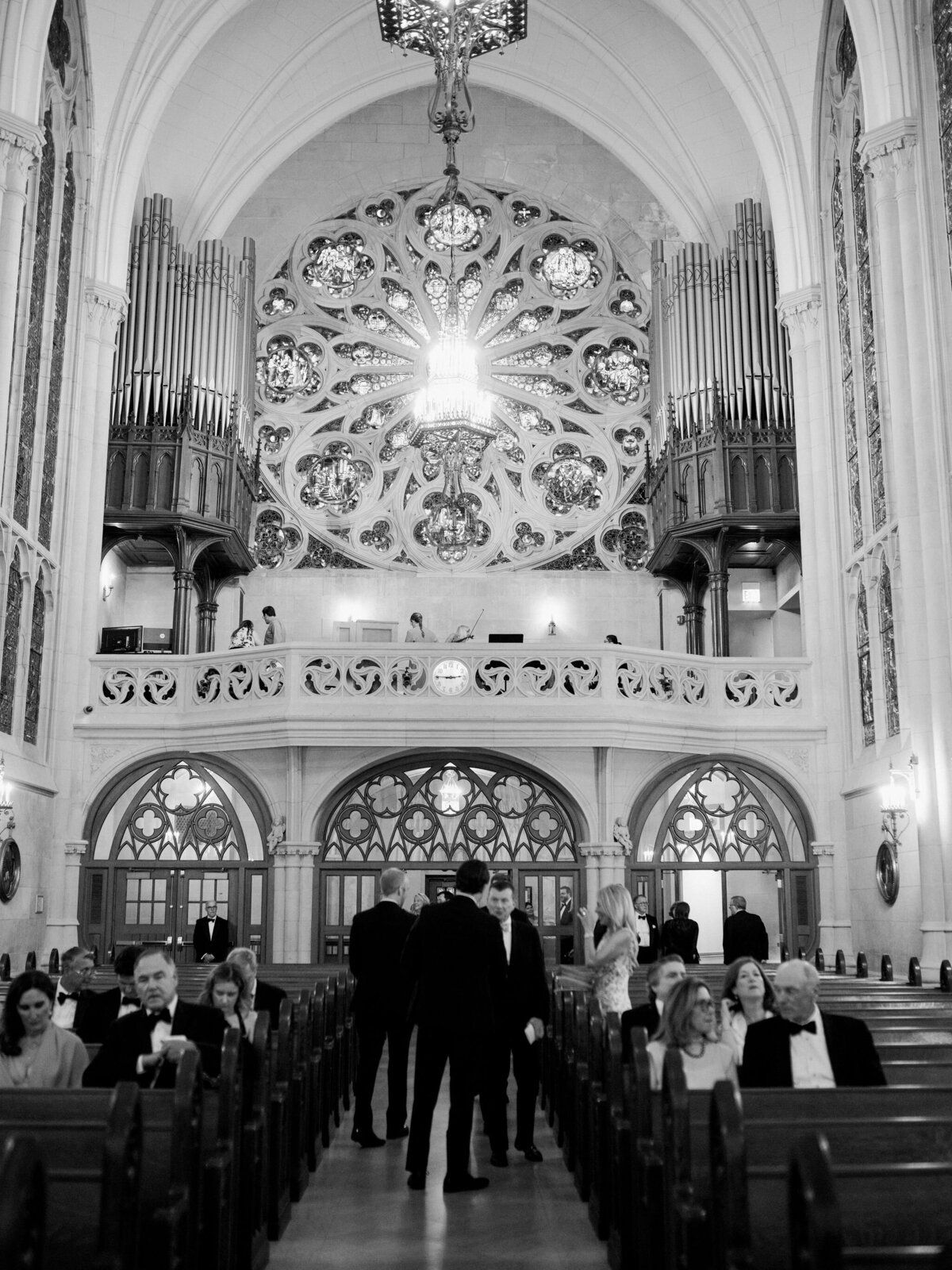 Interior of a grand church with guests seated for the wedding ceremony.