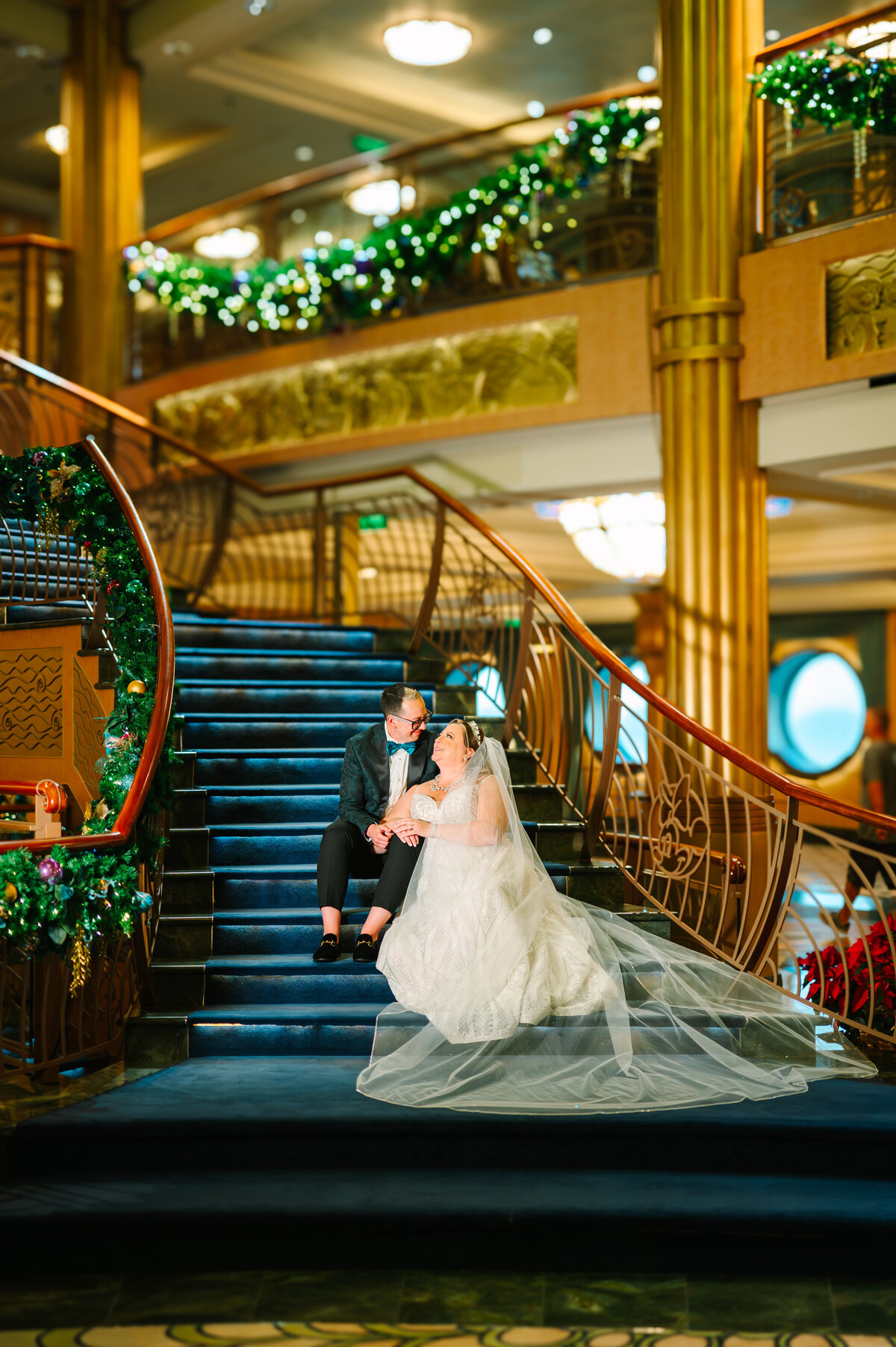 Couple sitting on the stairs of the fantasy atrium in wedding attire