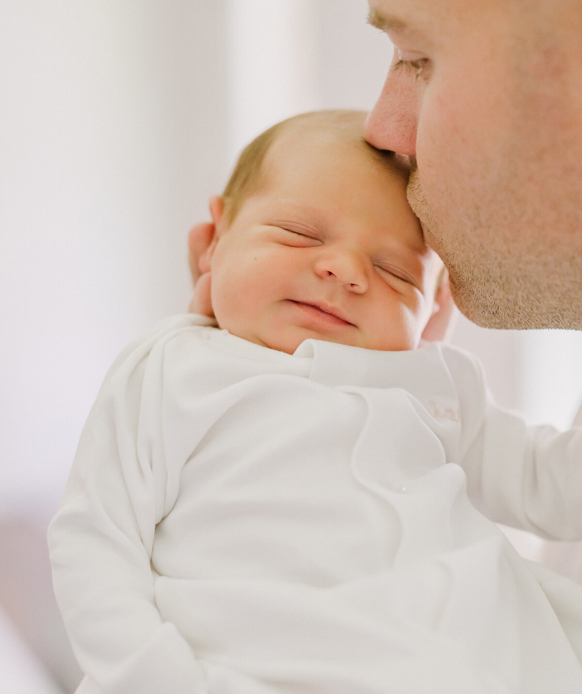 Father kissing a baby on the head.