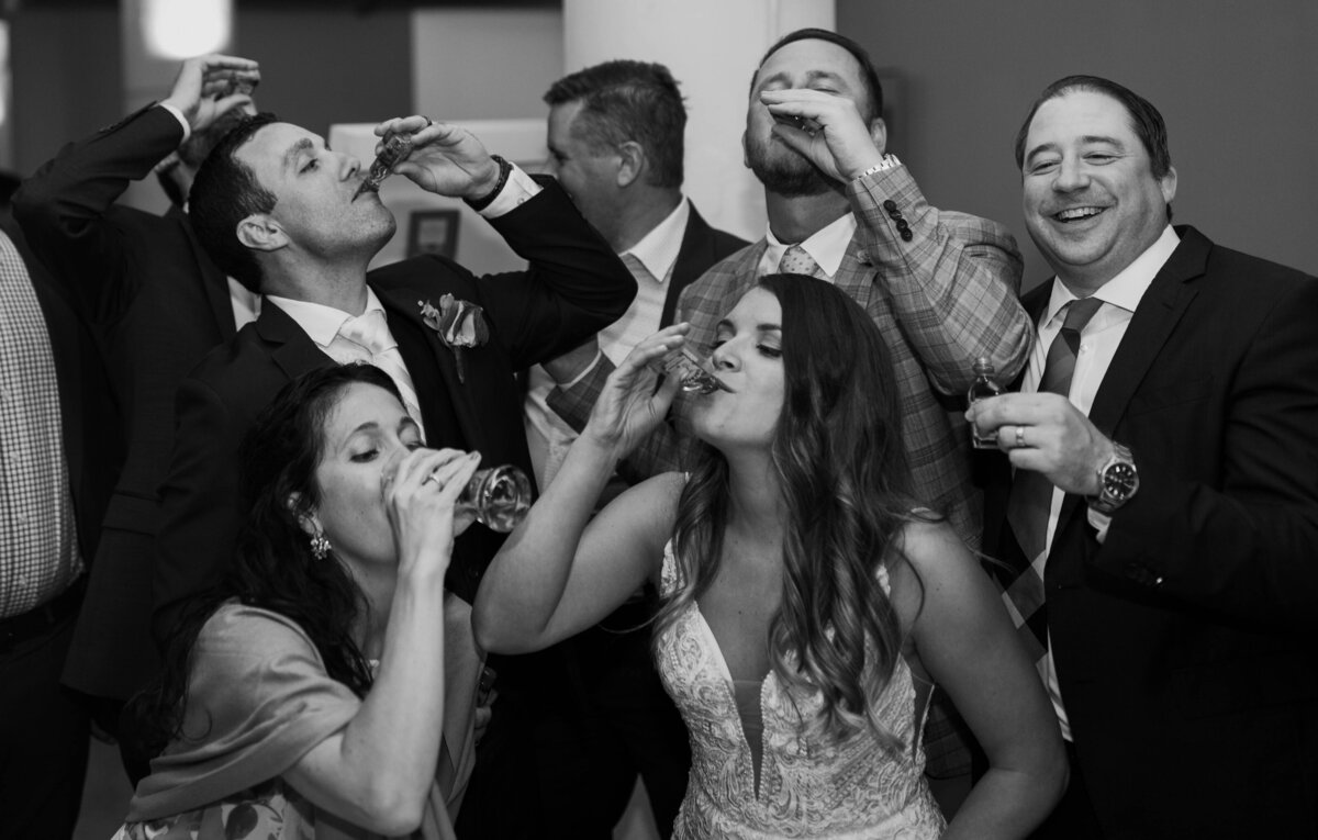 reception bride taking fireball shots with friends