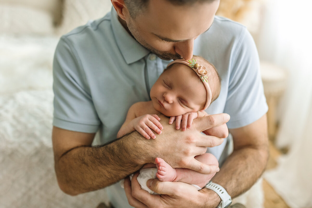Baby held by dad at newborn portrait studio