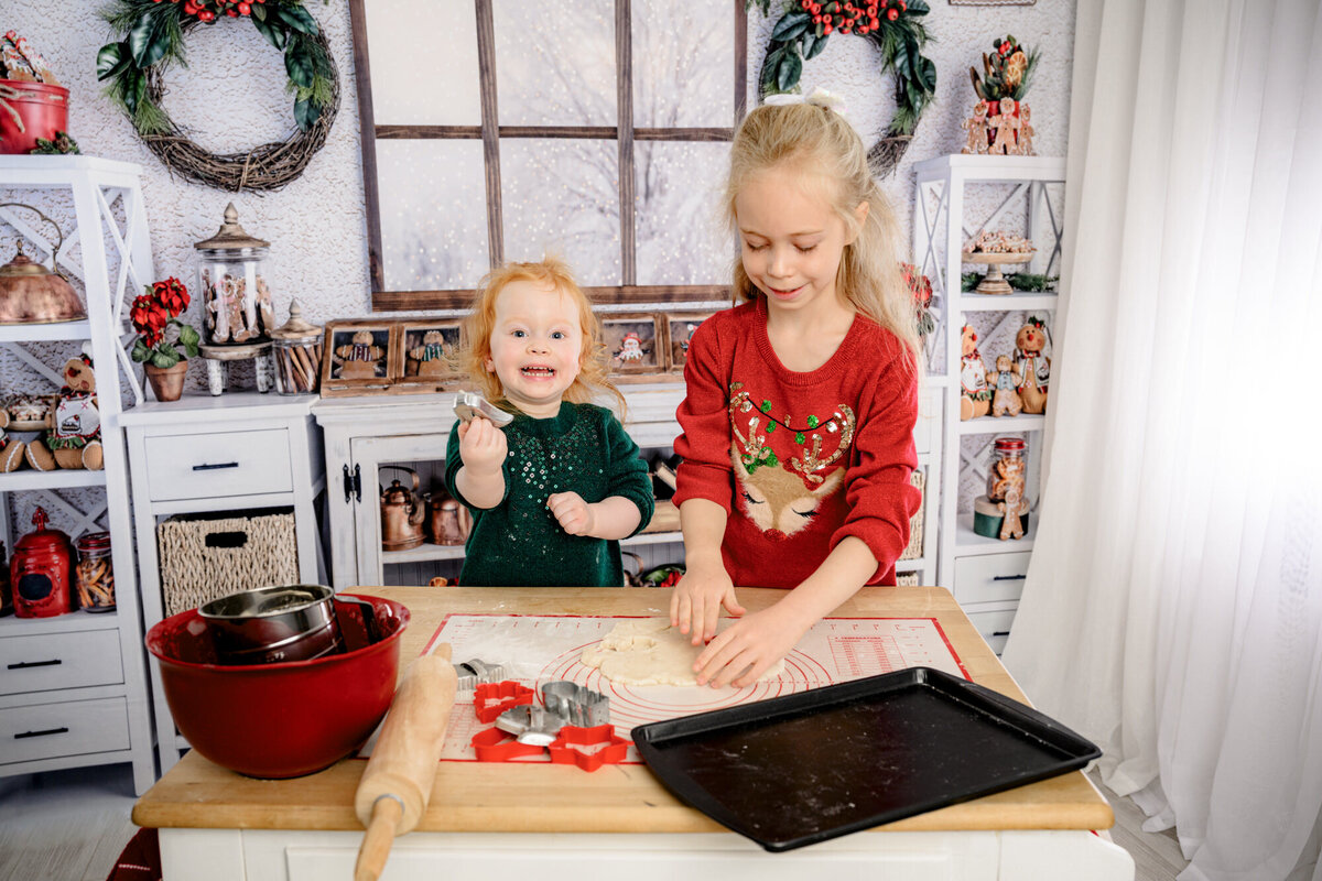 two little girls in a holiday christmas set up 