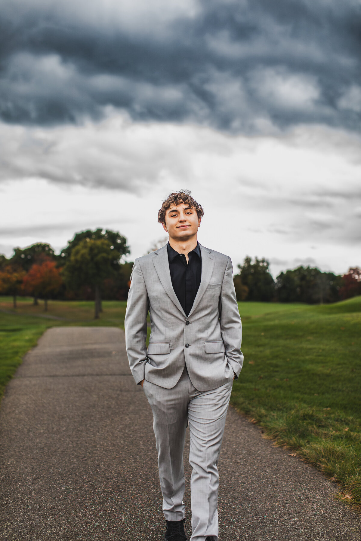 Pittsburgh senior photos of confident young man leaning against a brick wall.
