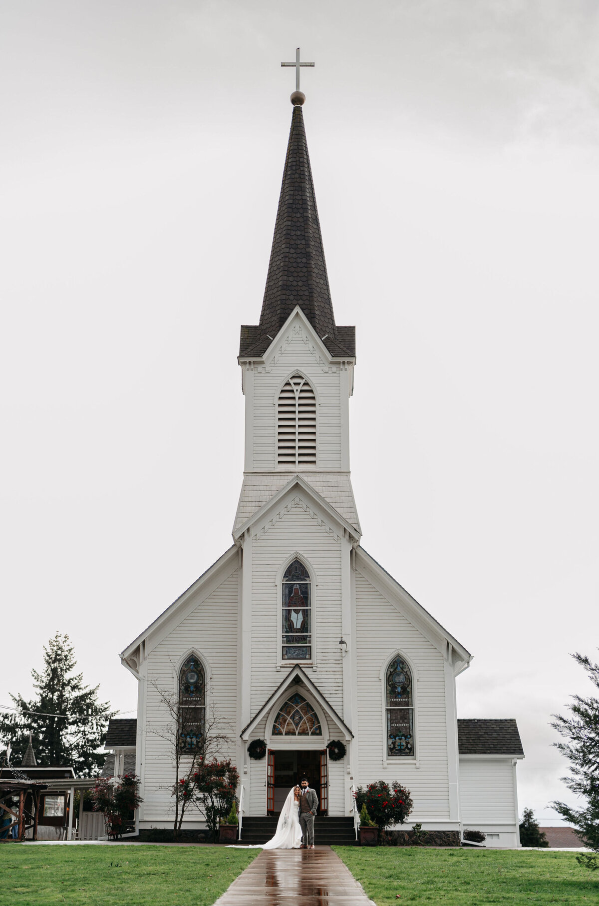 a bride an groom standing outside of a church