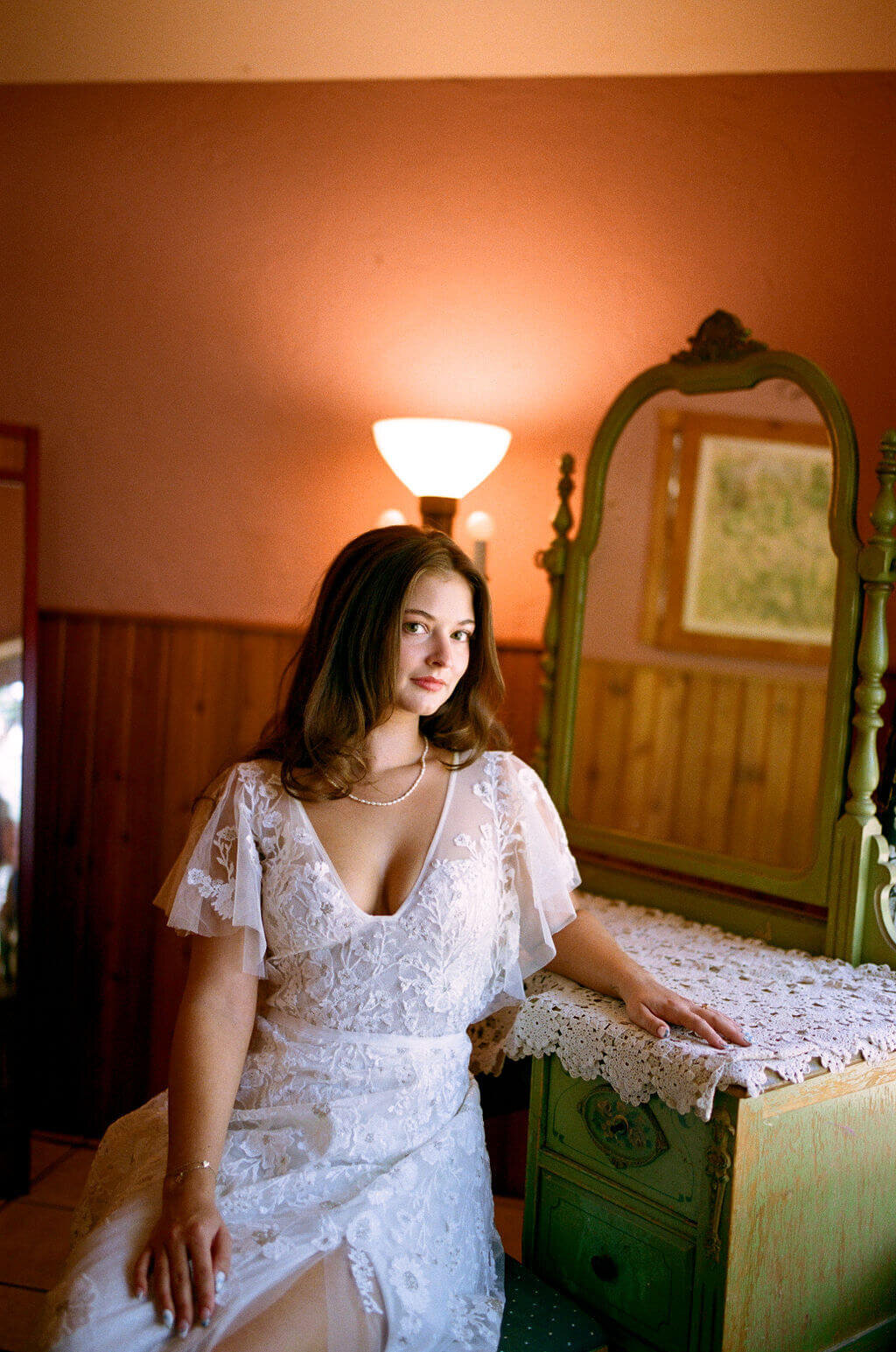 A bride smiling at the camera before her outdoor vintage garden wedding.
