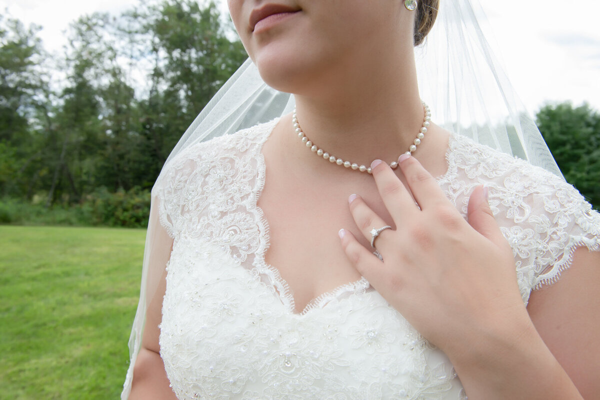 Bride touching her pearls on her wedding day