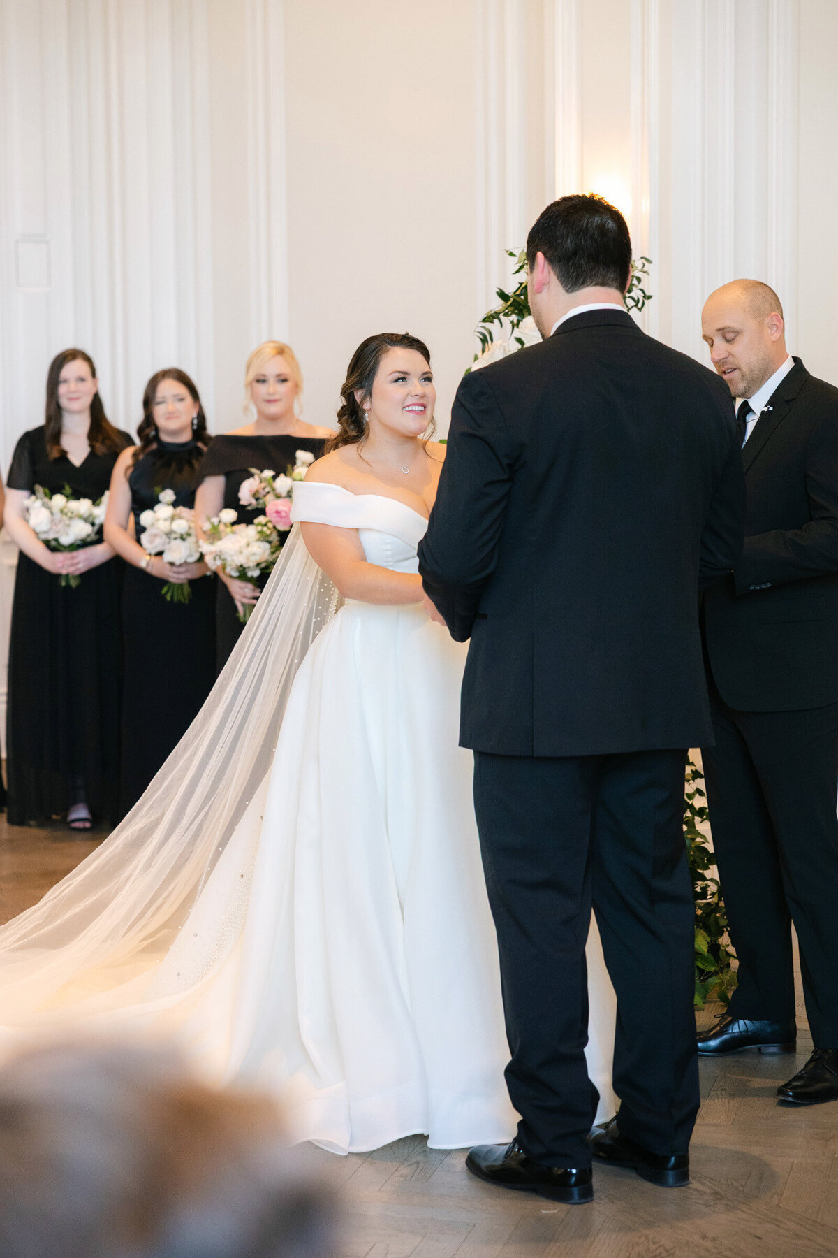 bride looking at the groom during their ceremony in the Governor’s Room at The Adolphus in Dallas, capturing a tender and intimate wedding moment.