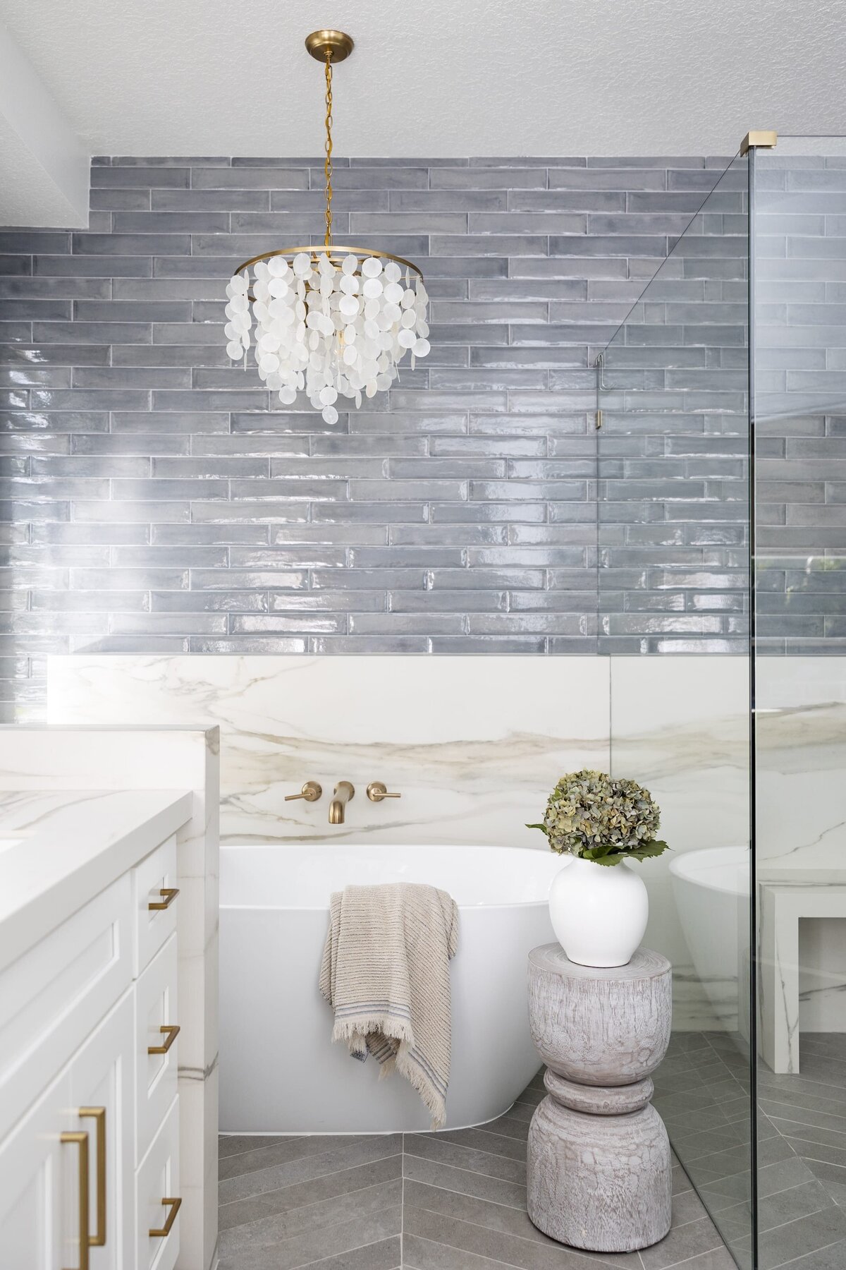 dewine design orlando interior designer contemporary coastal primary bathroom with standing tub and accent light fixture
