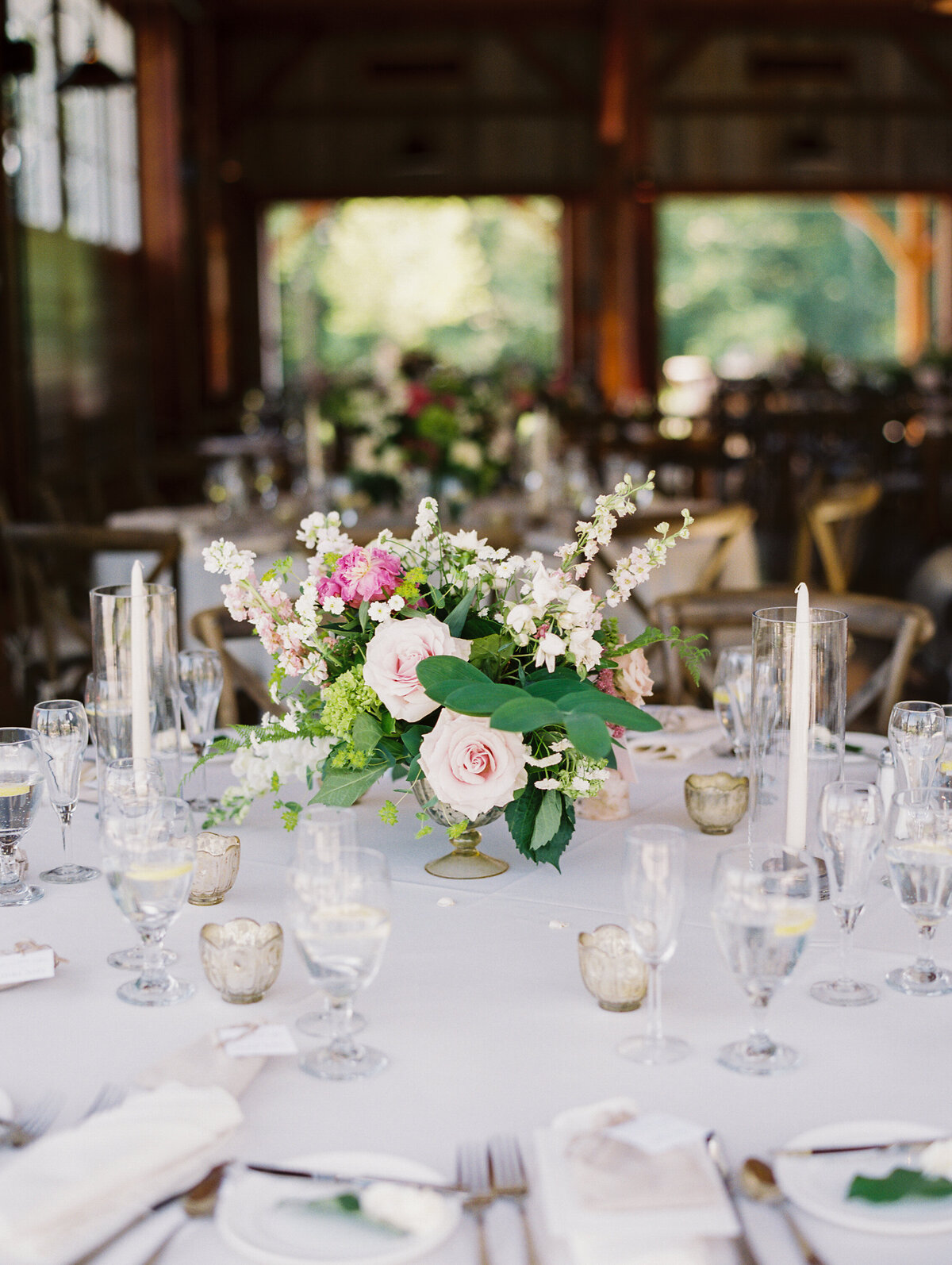 Table decorated with white tablecloth and pink and green floral centerpiece