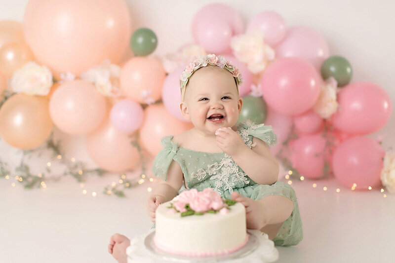 A pink and green cake smash for a baby girl's first birthday
