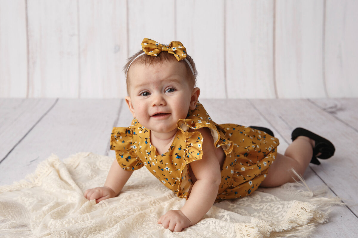 Cute photo of a 6 month old laying on her tummy photographed by Madison Milestone Photographer in Orfordville.