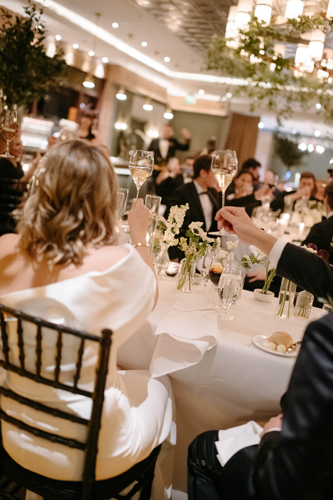Bride and groom toasting with champagne at St. Regis Aspen, celebrating their wedding surrounded by friends and family.