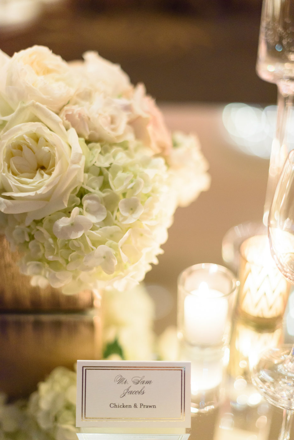 White hydrangea and polo roses softly lit by candles wedding designed by Flora Nova.