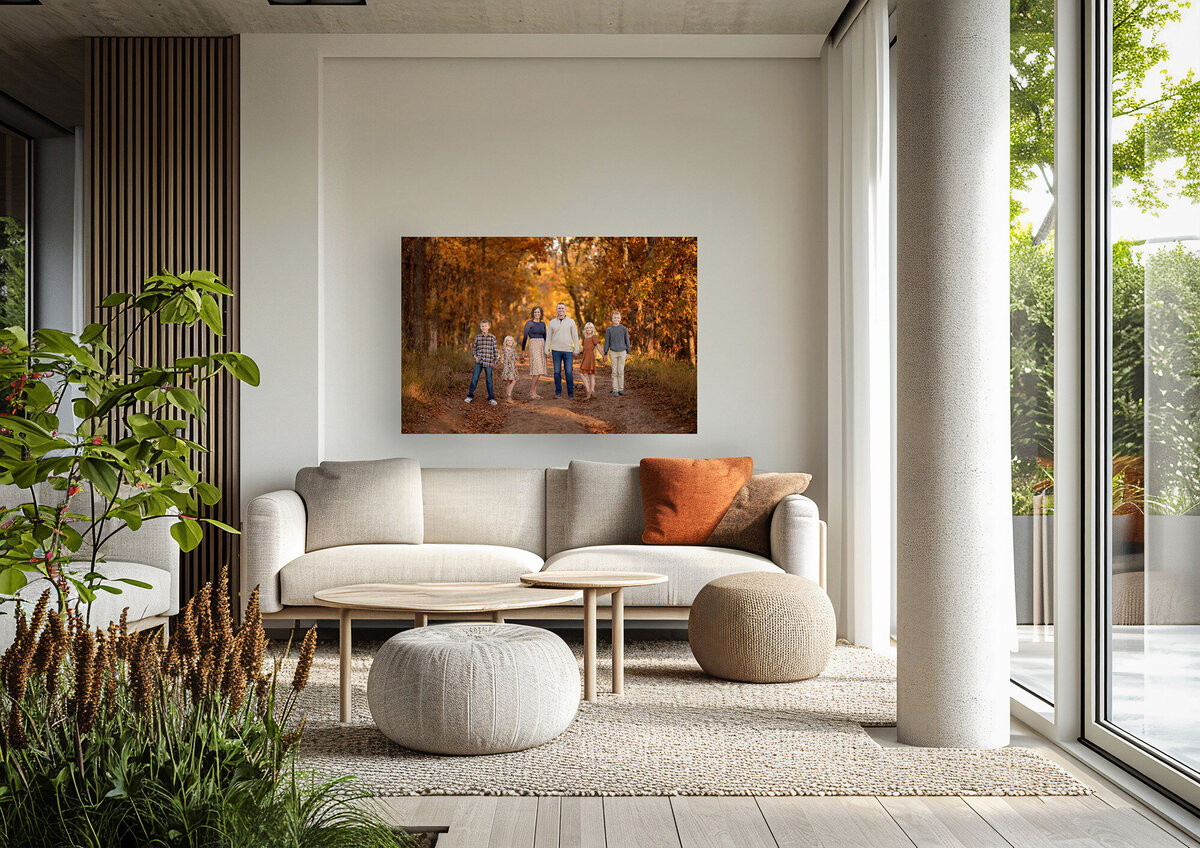A canvas of a family in fall foliage hangs over a couch