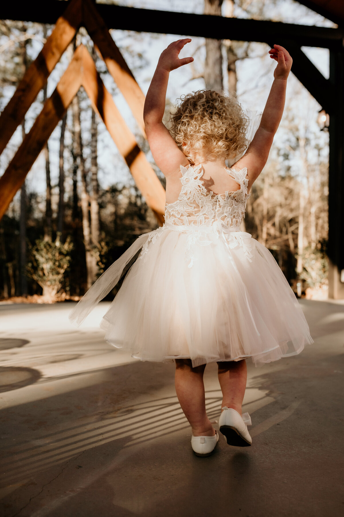 Little Rock wedding photographer captures flower girl dancing in her tulle and lace dress