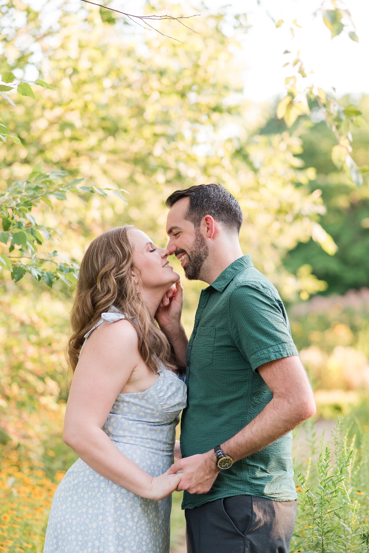 couple holding hands surrounded bu greenery