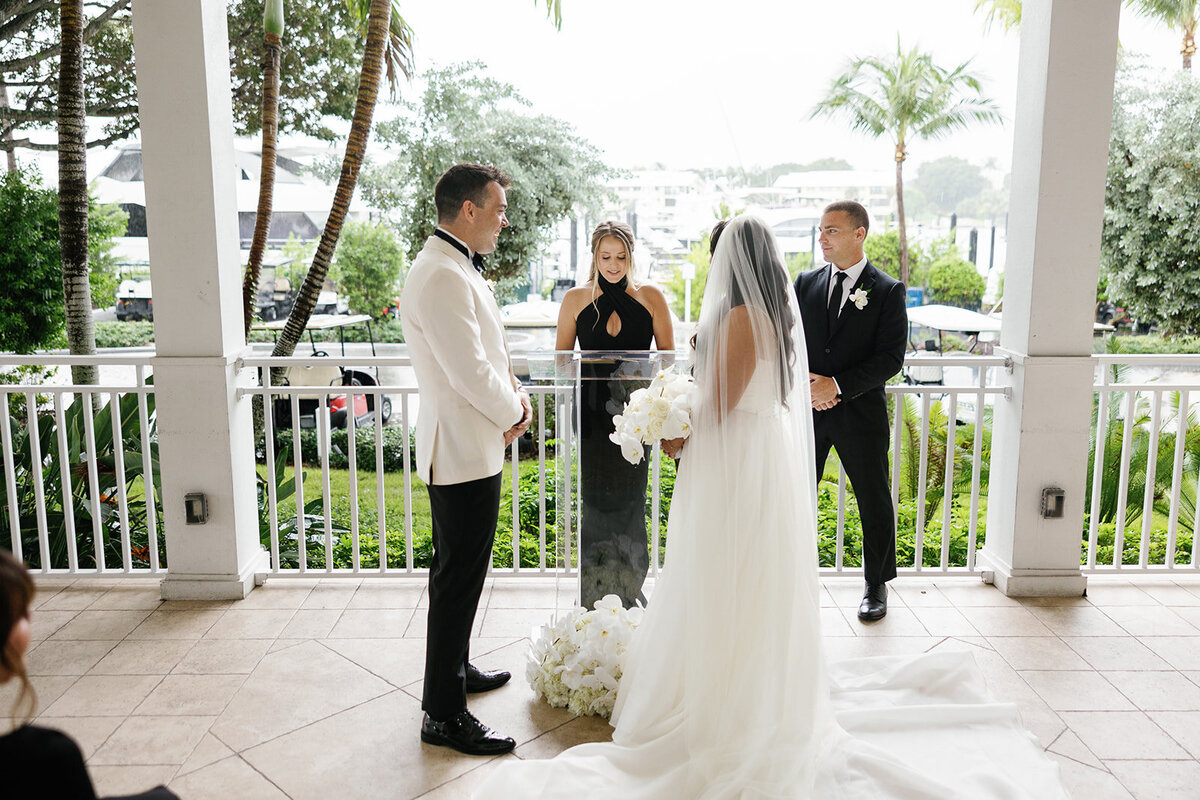 A wide-angle view of the wedding ceremony with Ashley and Cameron at Ocean Reef in Key Largo, framed by lush greenery and elegant decor, captured by Claudia Amalia Photography.
