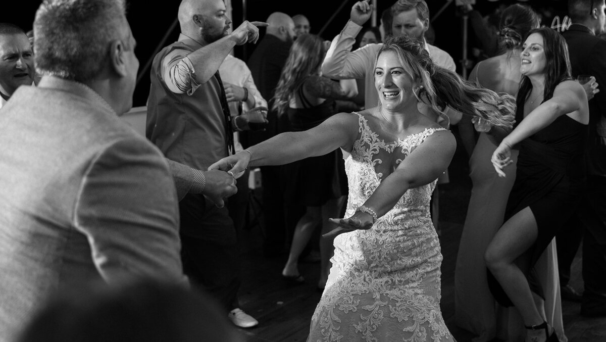 bride dances with guest at reception photo by cait fletcher photography
