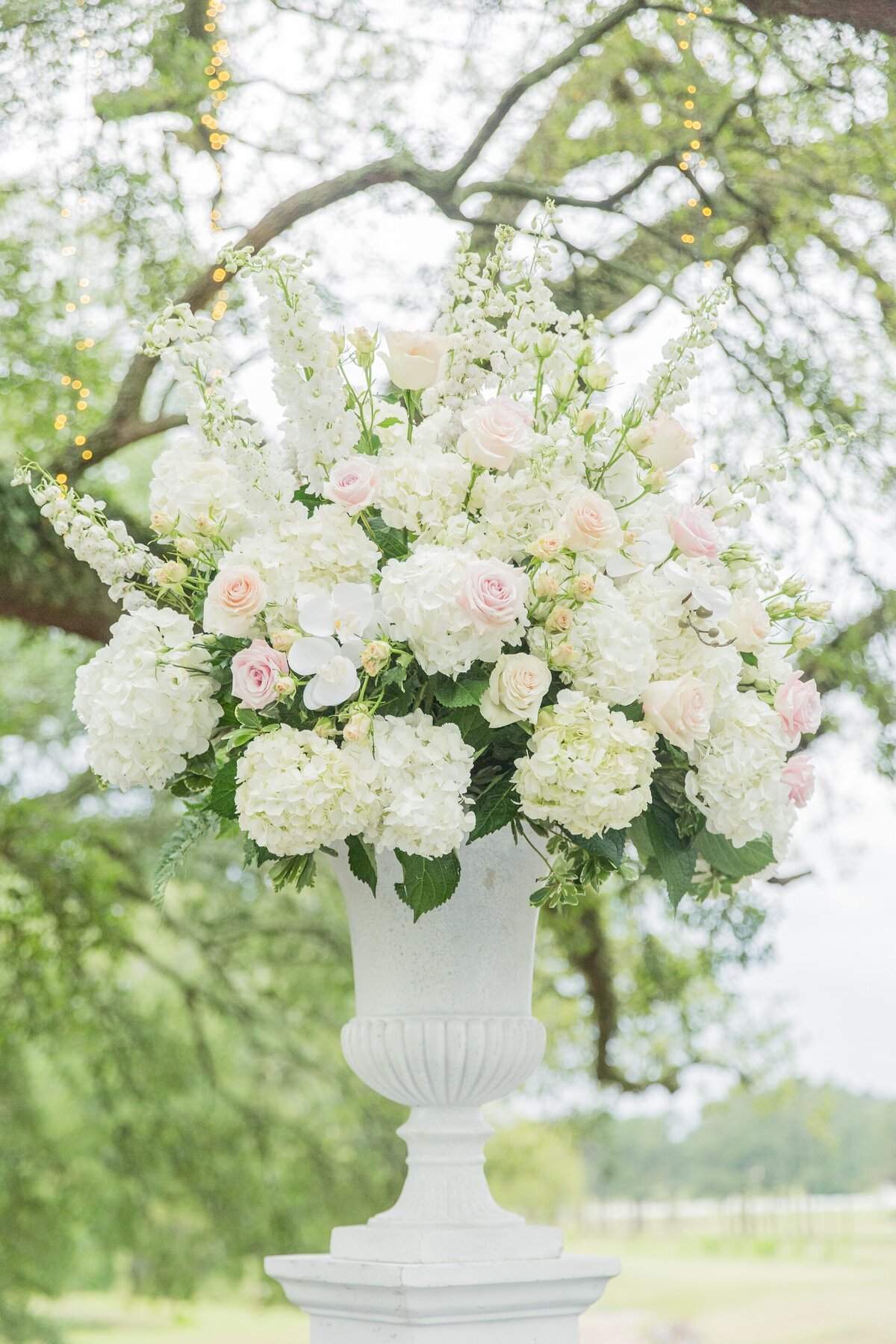 a white urn decorated with white flowers