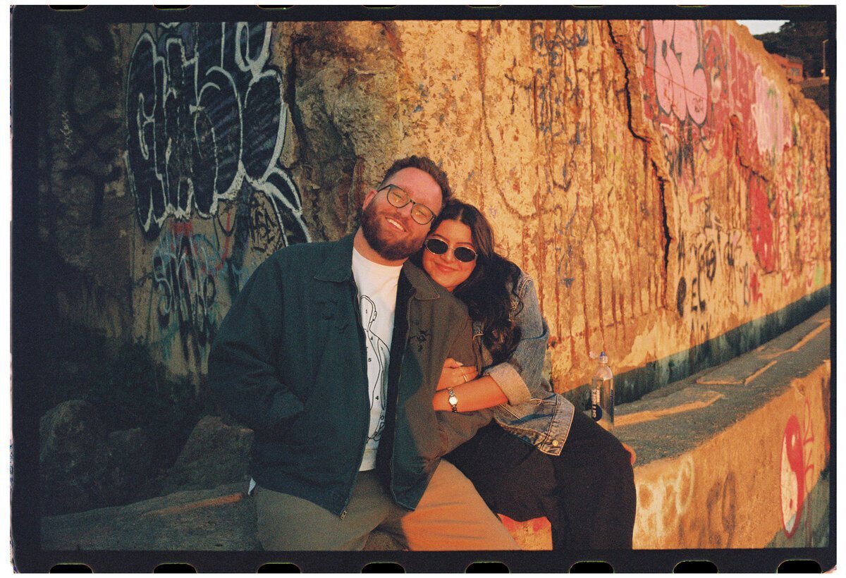 documentary style wedding photographer Christian Noble with wife against wall