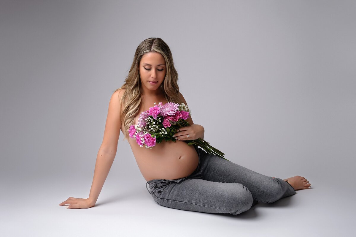 Pregnant woman poses with flowers for vogue style maternity photoshoot in West Palm Beach, FL.