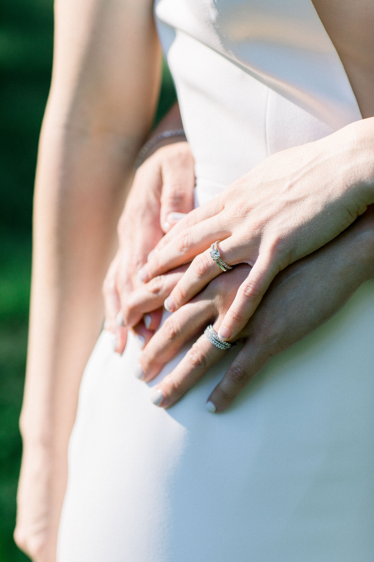 hands with wedding rings on white dress