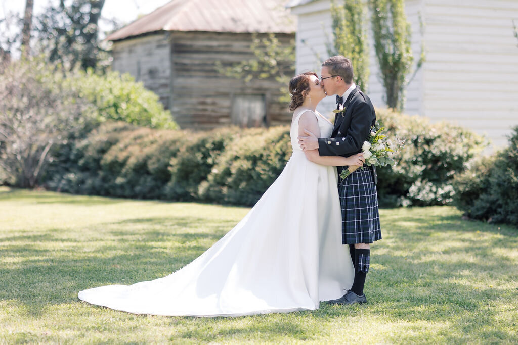 South Carolina Wedding Photographer | Bride and groom kissing in front of wedding venue