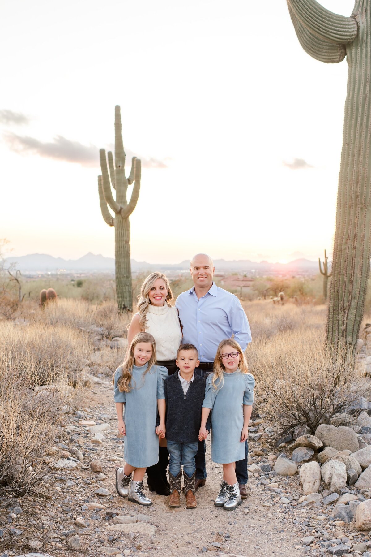 family of 5 posed standing in the desert smiling at the camera
